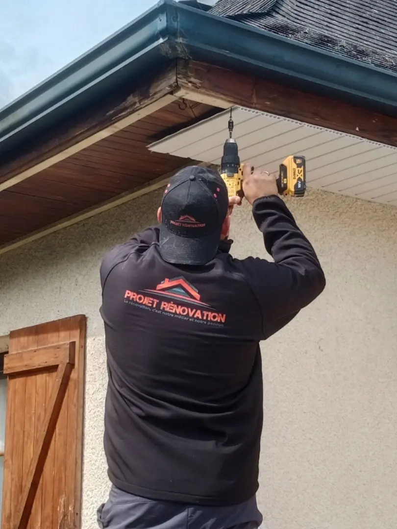 Artisan Projet Rénovation en intervention sous un débord de toit