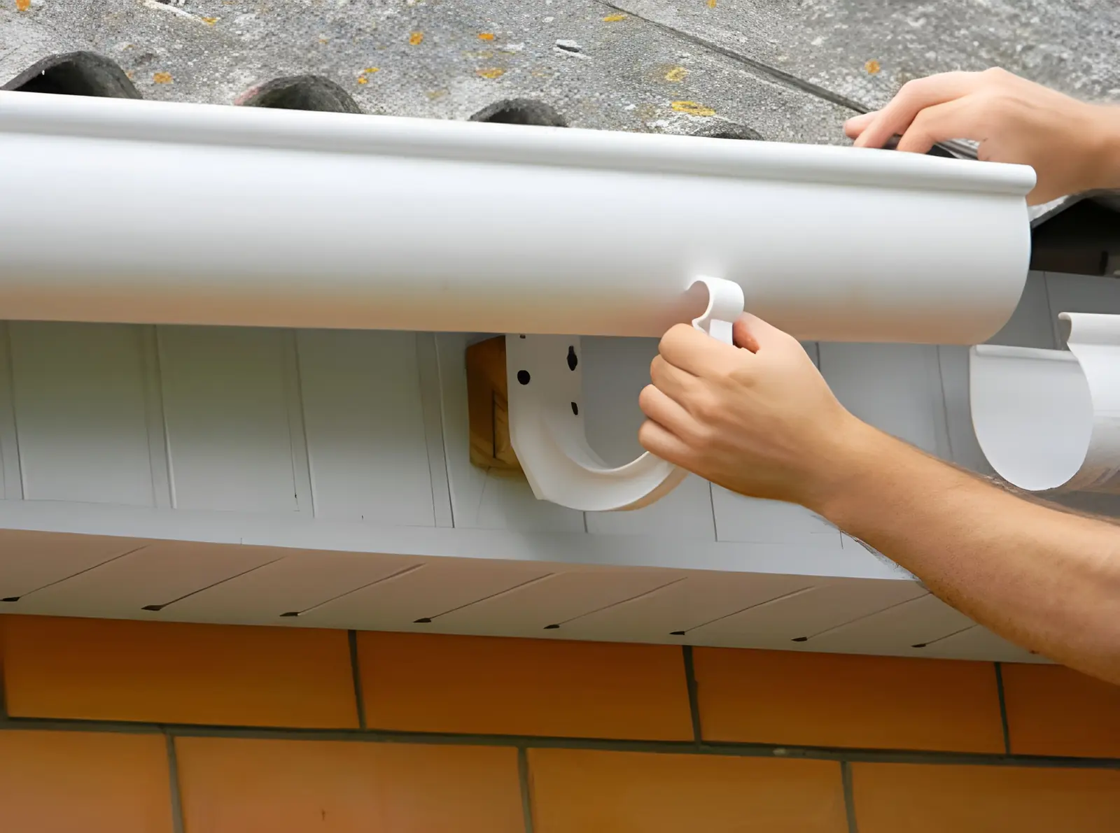 Pose d'une gouttière neuve en bas de toiture